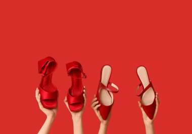 Kırmızı arka planda şık ayakkabıları olan kadın elleri.