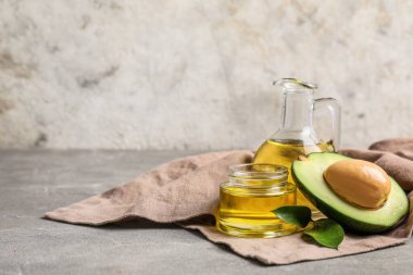 Gri zemin üzerinde avokado yağı olan kompozisyon