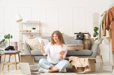 Evde yeni parfüm şişeleri olan genç bir kadın.