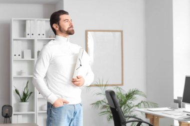 Dosyasıyla yukarı bakan genç bir adam.