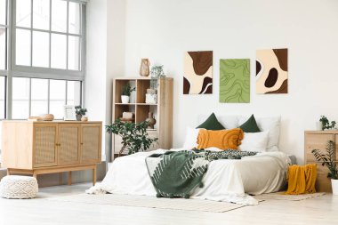 Şık yatak odaları, rahat yataklar, ev bitkileri ve güzel tablolar.