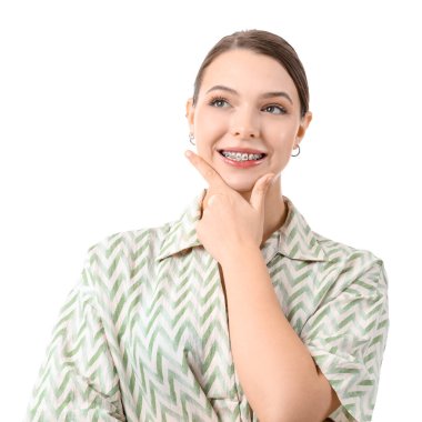 Beyaz arka planda diş telleri olan düşünceli genç bir kadın.