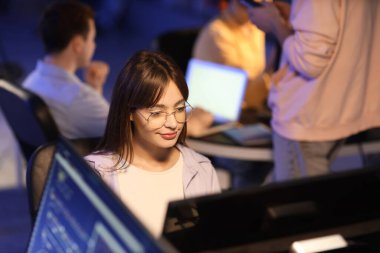 Geceleri ofiste çalışan kadın programcı.