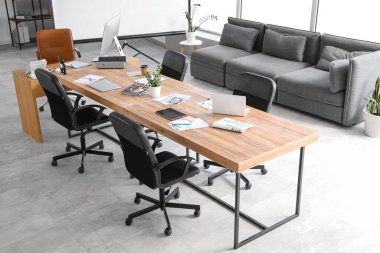 Konferans salonunun içinde masa ve kanepe var.