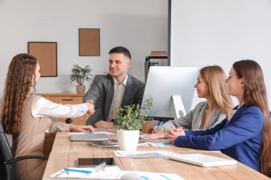 İş adamları konferans odasında el sıkışıyor.