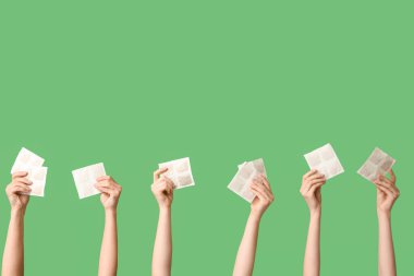 Yeşil arka planda hardal sıva olan kadın elleri.