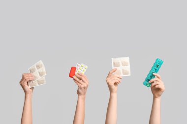 Gri arka planda hardal sıva, hap ve hap kutusu olan kadın elleri.