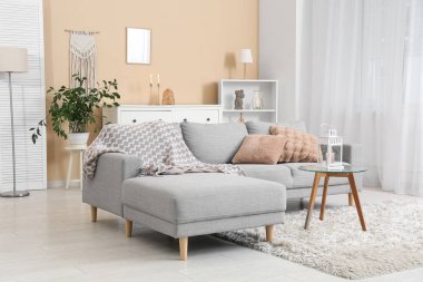 Oturma odasının içinde fener olan rahat bir kanepe ve kahve masası.