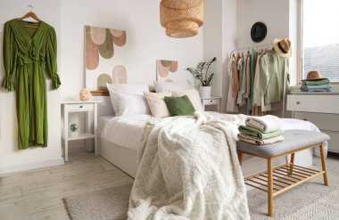 Rahat yataklı yatak odası ve elbiseli askı.