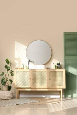 Çekmeceler ve katlanır ekran. Banyoda bej duvarın yanında.