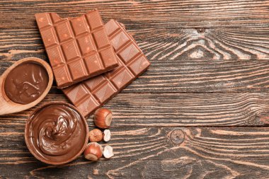 Tahta arka planda fındıklı bir kase dolusu çikolata.