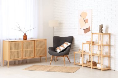 Odanın içinde ahşap raf ünitesi, koltuk ve tuvalet var.