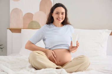 Evde vücut losyonlu hamile bir kadın var.