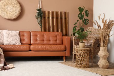 Rahat bir kanepe, otlar ve oturma odasının içindeki hasır koltuk.