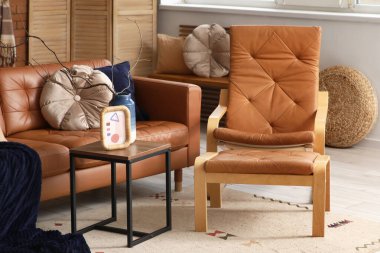 Oturma odası, deri kanepe, koltuk ve kahve masası.