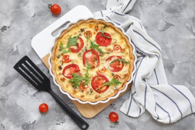 Gri arka planda roka yapraklı lezzetli domates tartı.