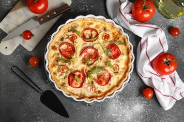 Koyu arkaplanda roka yapraklı lezzetli domates tartı.