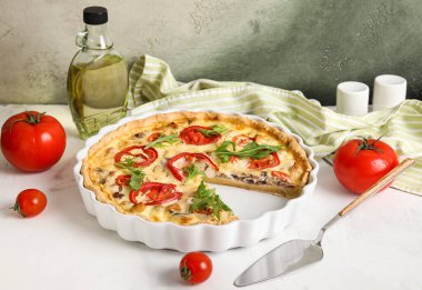 Beyaz masada roka yapraklı domatesli tart.