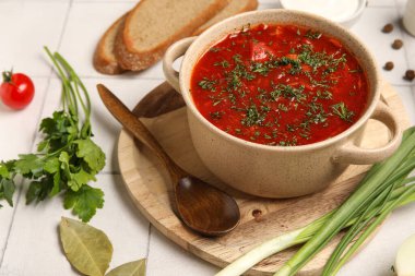 Bir kase lezzetli Ukrayna çorbası ve beyaz fayanslı malzemeler, yakın plan.