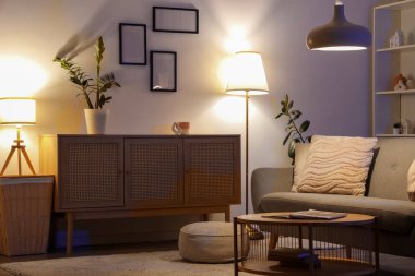 Gri kanepeli, masalı ve parlayan lambalı oturma odasının içinde.