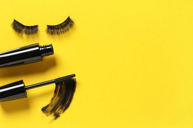 Lekeli siyah maskara ve sarı arka planda takma kirpik.