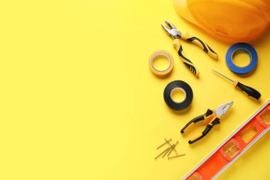 Sarı arkaplanda sert şapka ve inşaat araçları