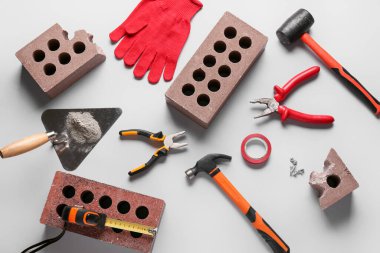 Gri arkaplanda tuğla ve inşaat araçları