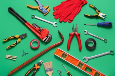 Yeşil arkaplanda eldivenler ve inşaat araçları