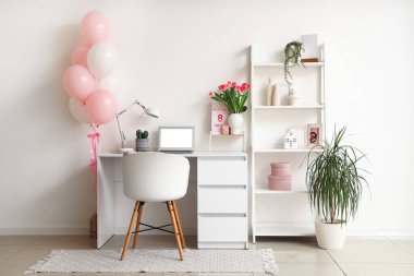 Kadınlar Günü için işyeri, raf ünitesi ve balonlarla dekore edilmiş ofis.
