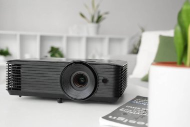 Modern projektör odadaki beyaz masada, yakın plan.