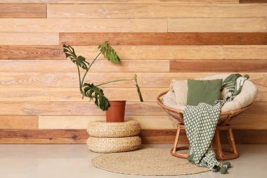 Hasır poufs üzerinde rahat koltuklu ve çiçekli şık bir oturma odası.