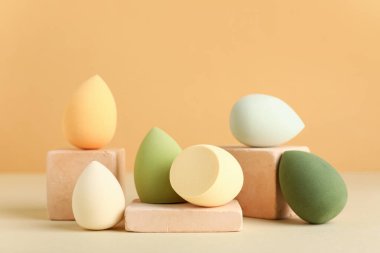 Bej arka planda makyaj süngeri olan dekoratif podyumlar