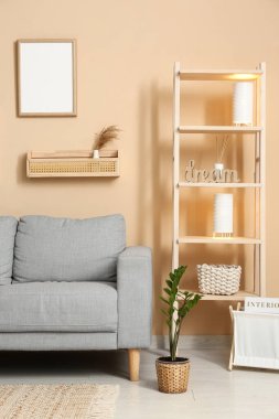 Oturma odasında ahşap askıları ve lambaları olan gri kanepe.