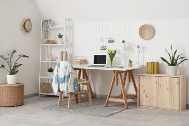 Çalışma yeri, çiçekler ve raf ünitesi olan ışık ofisinin içi