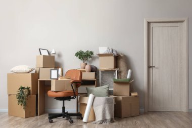 Taşındığı gün ışık duvarının yanında karton kutular olan çalışma yeri