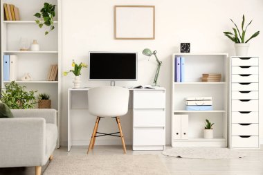 Çalışma odası, raf üniteleri ve kanepe.