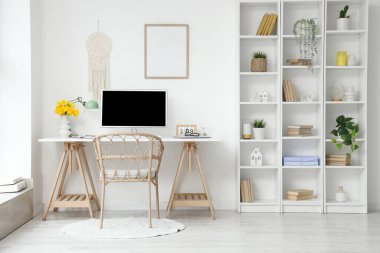 Çalışma yeri, çiçekler ve raf ünitesi olan ışık ofisinin içi