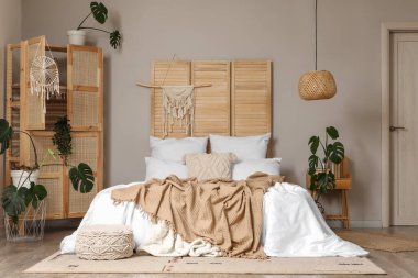 Odanın içi ahşap perdeli, raf üniteli ve bitkilerle dolu.