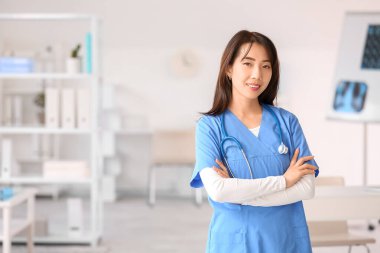 Klinikte gülümseyen Asyalı kadın doktor