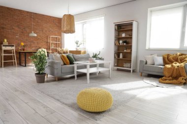 Koltukları, masası ve kitaplığı olan stüdyo dairesinin içinde.