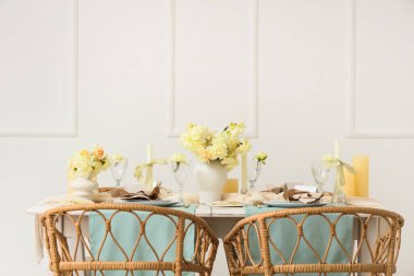 Narcissus çiçekleri ve mumlarla aydınlık odada güzel bir masa.