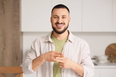 Evde işaret dili kullanan genç dilsiz adam.