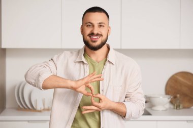 Evde işaret dili kullanan genç dilsiz adam.