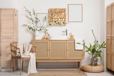 Lavabosu, çiçek açan dalları ve koltuğu olan banyonun içi.