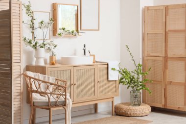 Lavabosu, çiçek açan dalları ve koltuğu olan banyonun içi.