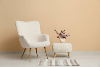 Beyaz koltuğu ve çiçek açan dalları olan şık bir oturma odası.