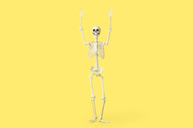 Sarı arka planı olan korkunç insan iskeleti.