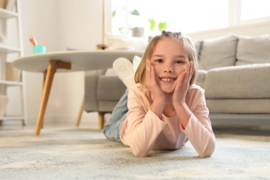 küçük kız evde halı üzerinde yalan