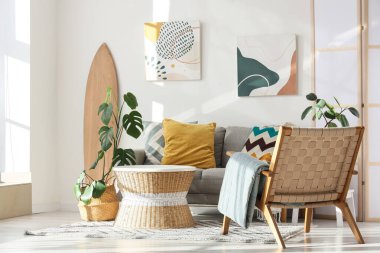 Sörf tahtası, kanepesi ve koltuğu olan bir oturma odası.