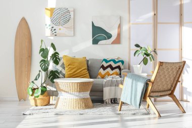 Sörf tahtası, kanepesi ve koltuğu olan bir oturma odası.